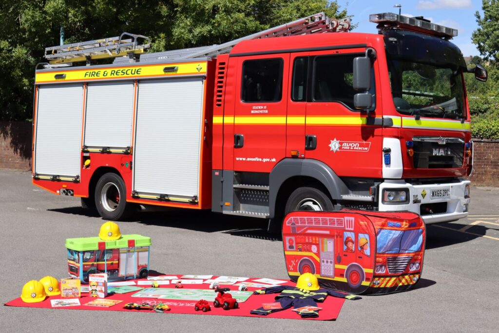 Fire engine with the contents  of the Early Years Foundation Stage page laid out the front, including dress up outfits, pop up fire engine, and jigsaw puzzles.