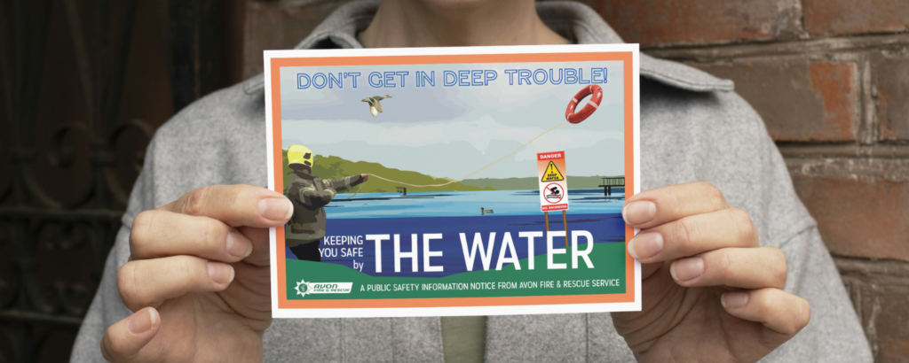 persona holding postcard with vintage-inspired design that says 'don't get in deep trouble!' and 'keeping you safe by the water'. with a firefighter wearing a yellow helmet who is throwing a lifering into some still water.