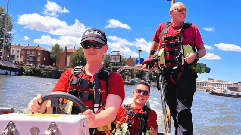 Female Firefighter driving recue boat with two other male firefighters