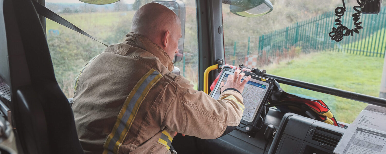 Firefighter in fire engine using tablet software
