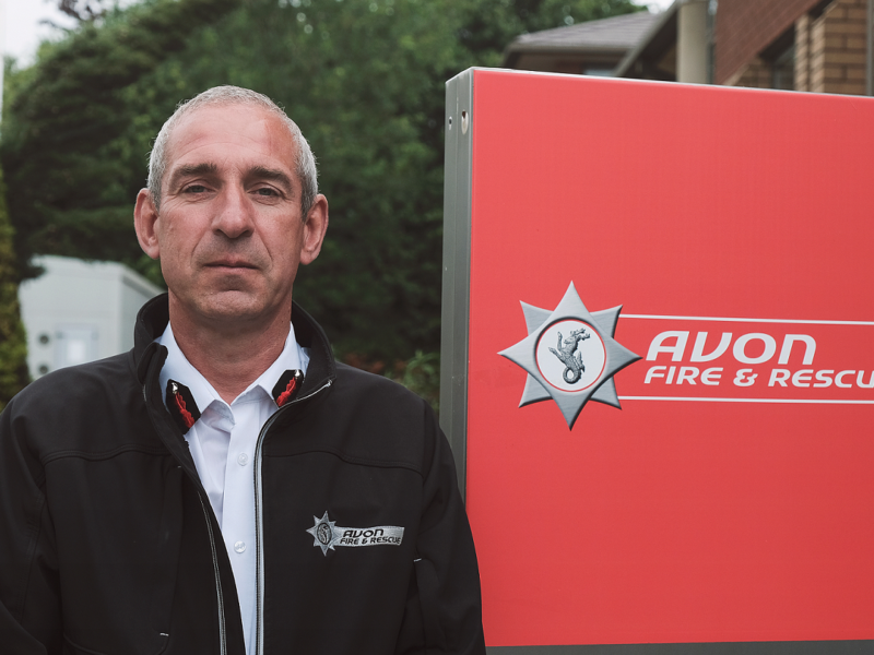 Simon Shilton next to Avon Fire and Rescue Service logo