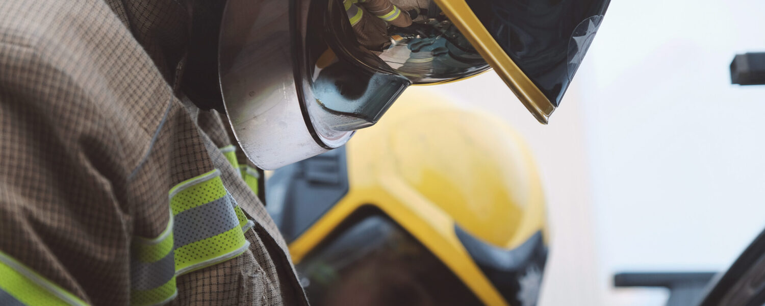 Close up of Firefighters in helmet focusing on cutting up a car