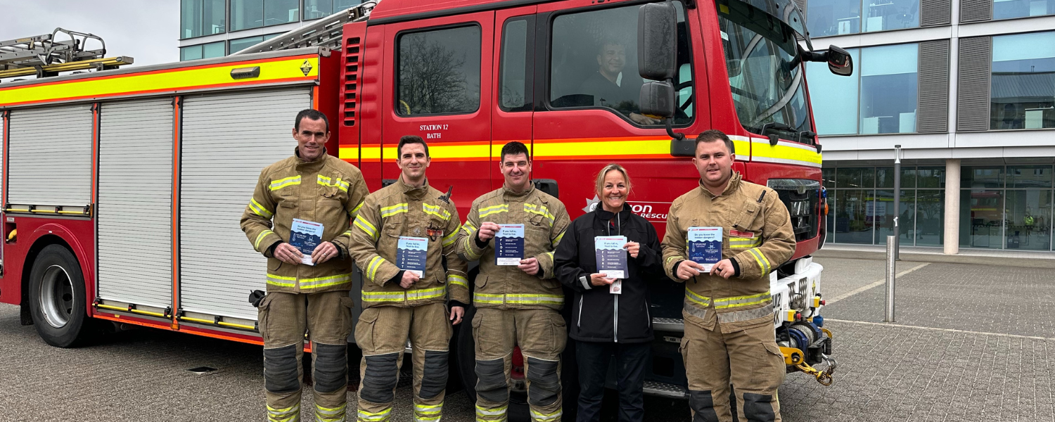 firefighters standing holding leaflets in front of a fire engine at Bath university