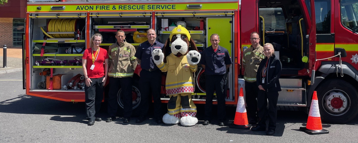 A group of people standing next to a fire truck in a parking lot.