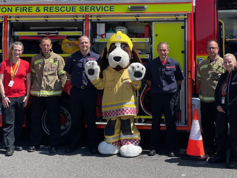 A group of people standing next to a fire truck in a parking lot.
