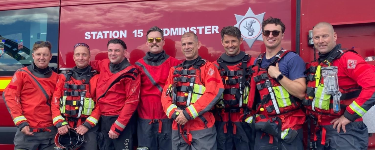 A group of men standing next to each other in front of a fire truck