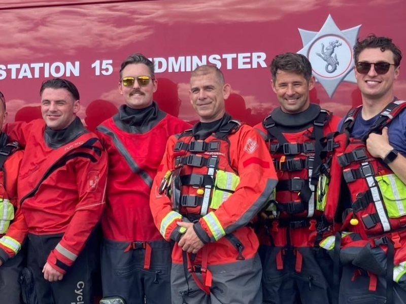 A group of men standing next to each other in front of a fire truck