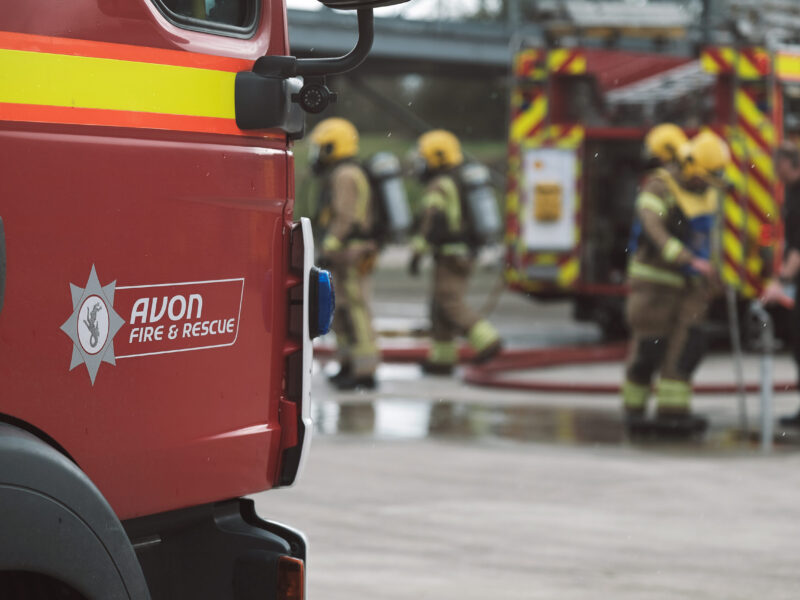 Fire engine in the front with firefighters working in the background