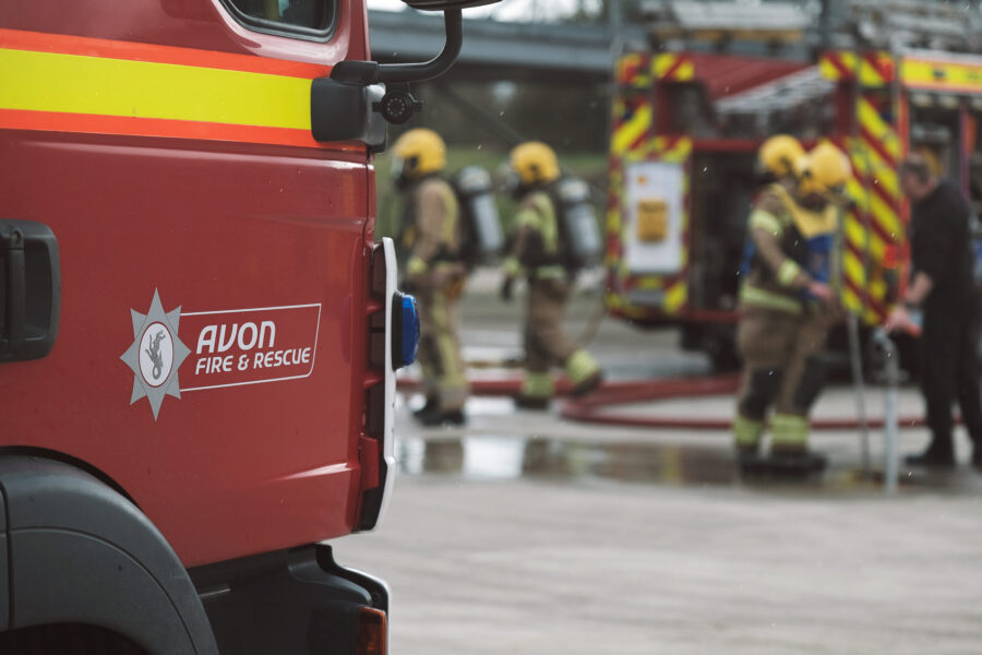 Fire engine in the front with firefighters working in the background