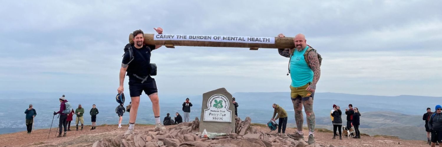 Two firefighters standing at the summit of Pen y Fan