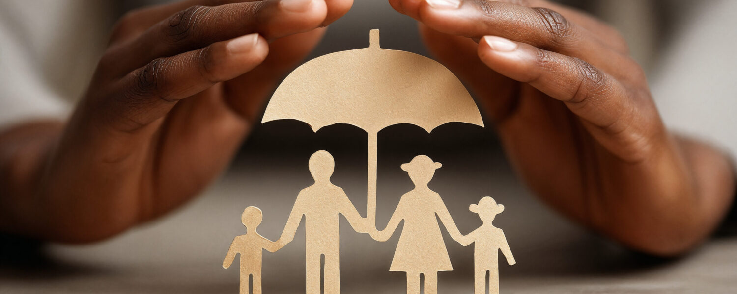 Female hands protecting paper cut-out family under umbrella symbolising safeguarding
