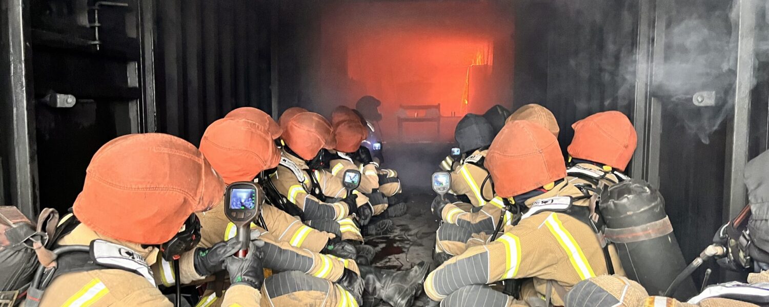 Wholetime firefighter recruits using thermal imaging cameras in hot fire training at Severn Park Training Centre