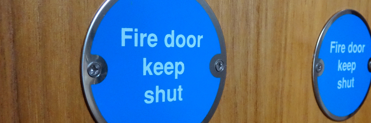 Image of a fire door with blue sign saying fire door keep shut