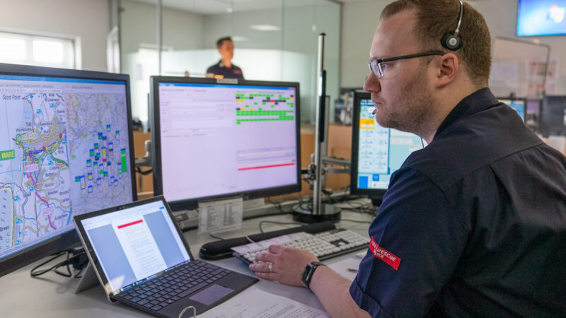 Fire Control Operator at desk observing screens and taking a call