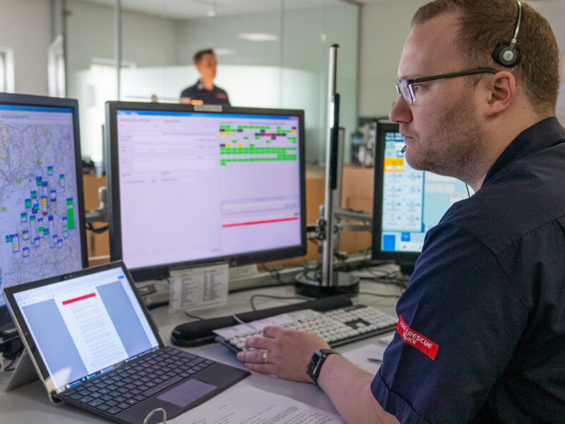 Fire Control Operator at desk observing screens and taking a call
