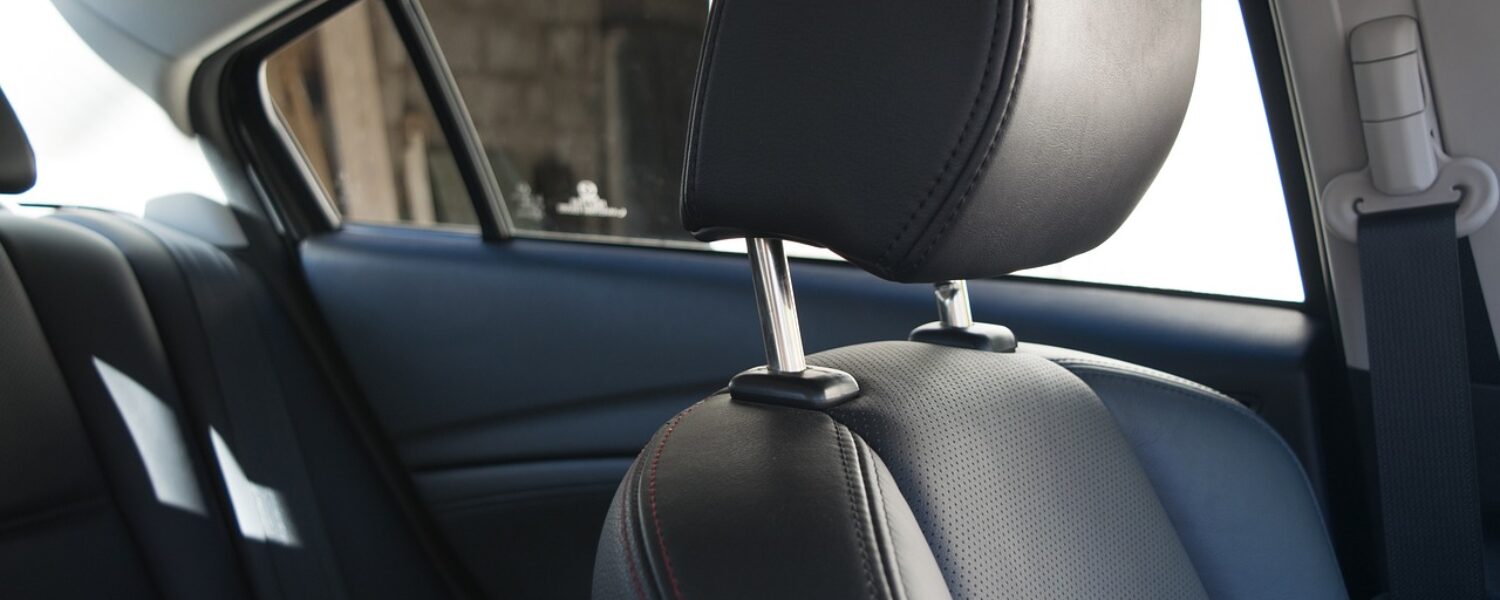passenger side car seat with rear seats and rear passenger side window shown, black leather interior