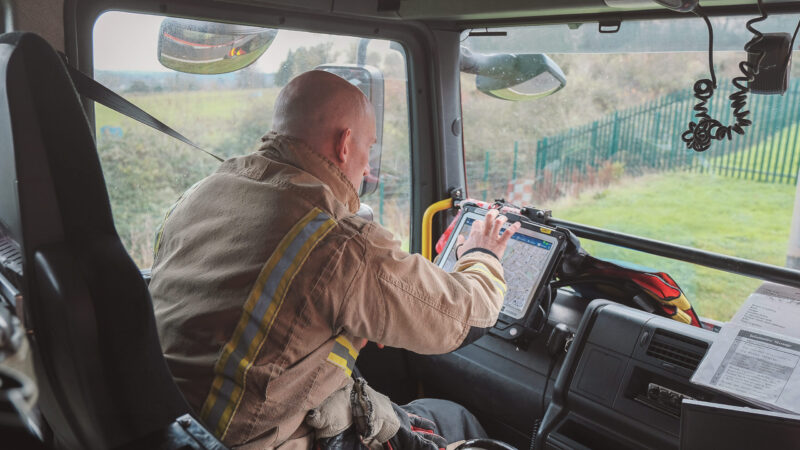 Firefighter in fire engine using tablet software