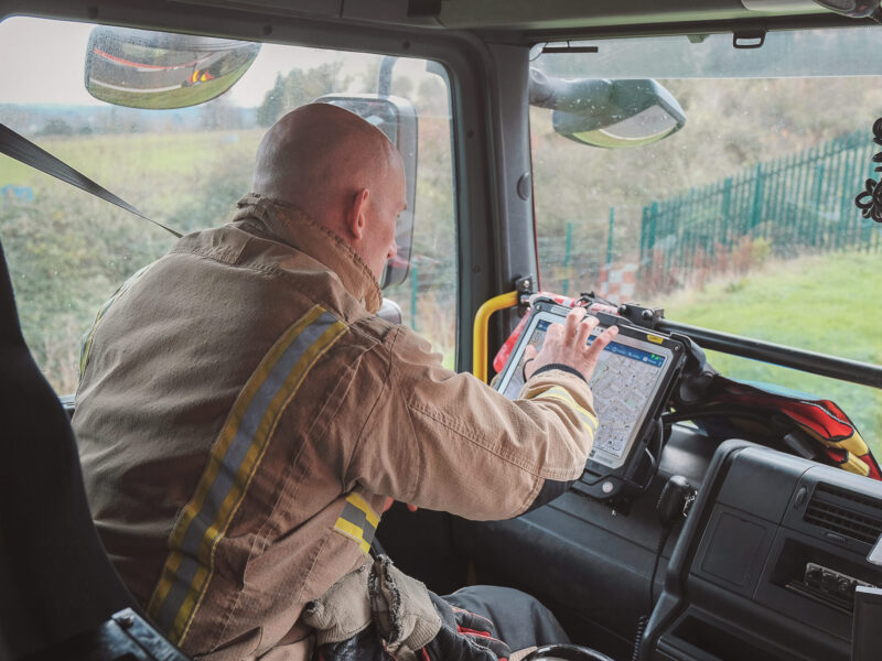 Firefighter in fire engine using tablet software