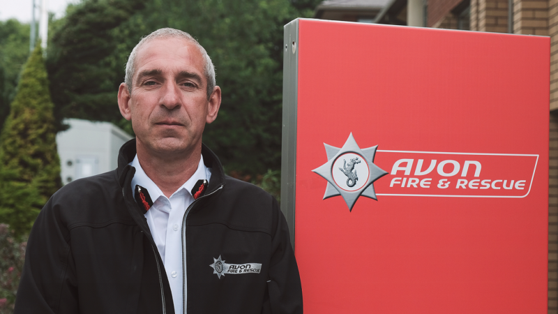 Simon Shilton next to Avon Fire and Rescue Service logo