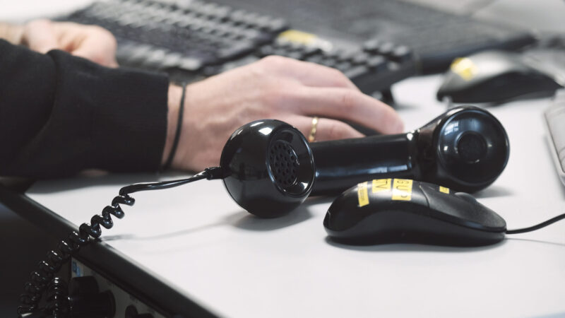picture of two hands on key board and mouse with close up of telephone headset