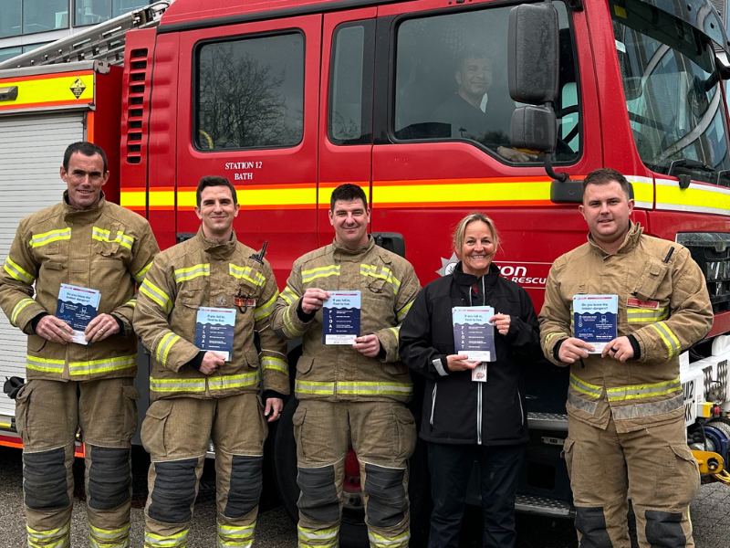 firefighters standing holding leaflets in front of a fire engine at Bath university