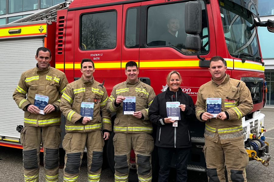 firefighters standing holding leaflets in front of a fire engine at Bath university